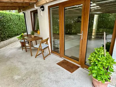 a patio with a wooden door and a table and chairs at Alpine Echo Apartments in Bovec