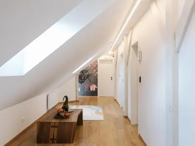 a white hallway with a wooden coffee table and a white wall at Lilija apartments in Trzin