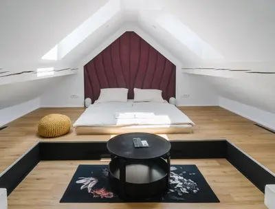 a attic bedroom with a bed and a table at Lilija apartments in Trzin