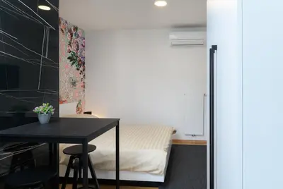 a small bedroom with a bed and a table at Lilija apartments in Trzin