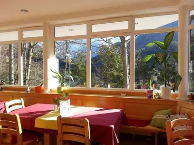 a dining room with two tables and a large window at Rooms Barovc by the Lake Jasna in Kranjska Gora