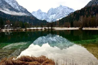 a large lake with snow capped mountains in the background at Rooms Barovc by the Lake Jasna in Kranjska Gora