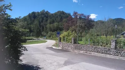 a road with a stone fence and a stone wall at Apartment Lošč - Podbela in Breginj