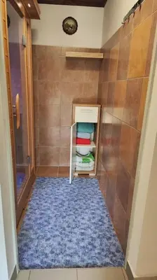 a small bathroom with a small refrigerator in a room at Počitniška hiška v gozdnem raju in Črni Vrh