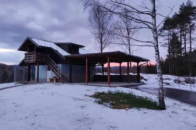 a building with a roof in the snow at Počitniška hiška v gozdnem raju in Črni Vrh