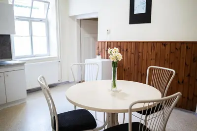 a white table with chairs and a vase of flowers on it at Apartmaji PAJTLER in Zgornja Kungota