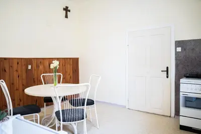 a kitchen with a table and chairs and a white door at Apartmaji PAJTLER in Zgornja Kungota