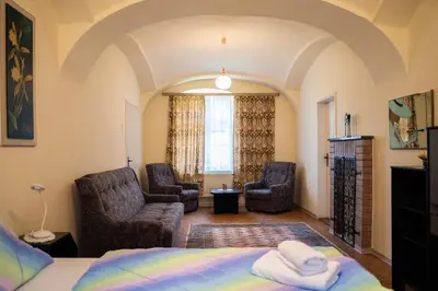 a bedroom with a bed and two chairs and a window at Apartmaji PAJTLER in Zgornja Kungota