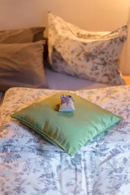 a green pillow sitting on top of a bed at Apartments Ukanc in Bohinj