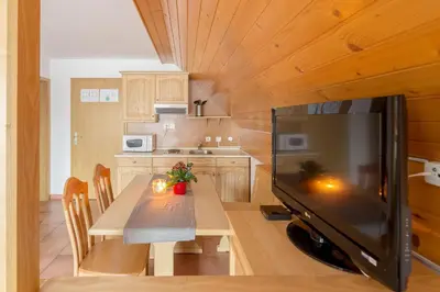 a small kitchen with a table and a television at Apartments Ukanc in Bohinj