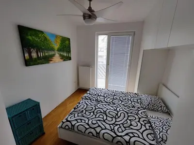 a bedroom with a bed and a painting on the wall at Sunshine apartment Bled in Bled