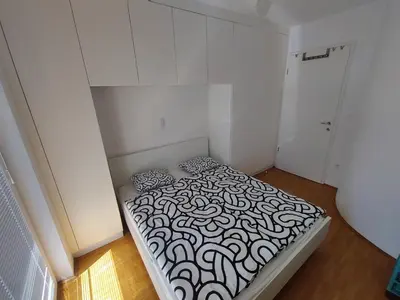 a small bedroom with a bed with a black and white pattern at Sunshine apartment Bled in Bled