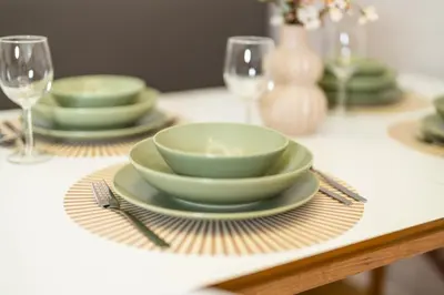 a table with a bowl and plates and wine glasses at Bubbly Apartment in Bled