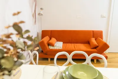 an orange couch sitting in a living room at Bubbly Apartment in Bled