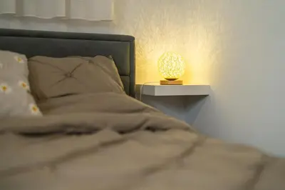 a bed with a lamp on a side table at Bubbly Apartment in Bled