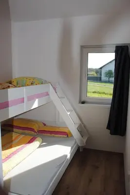 a small room with a bunk bed with a window at Hiška Mirna ravnica in Moravske Toplice