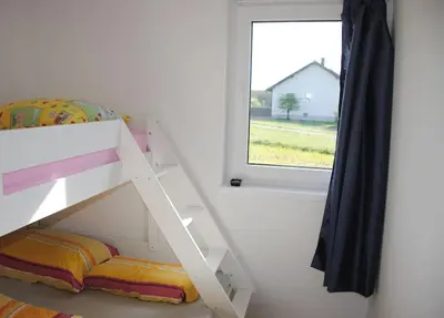 a white bunk bed in a room with a window at Hiška Mirna ravnica in Moravske Toplice
