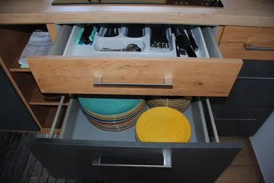 a drawer in a kitchen with plates and utensils at Hiška Mirna ravnica in Moravske Toplice