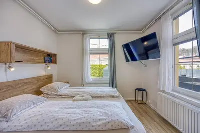 two beds in a room with a flat screen tv at Apartments Jantar in Novo Mesto