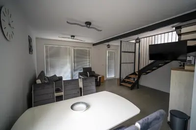 a living room with a white table and a tv at Apartma Tim Terme Čatež in Čatež ob Savi