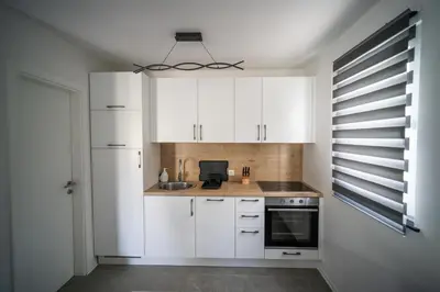 a kitchen with white cabinets and a sink at Apartma Tim Terme Čatež in Čatež ob Savi