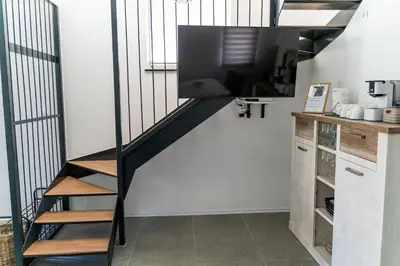a living room with a staircase with a flat screen tv at Apartma Tim Terme Čatež in Čatež ob Savi