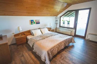 a bedroom with a large bed and a large window at Apartma Župelefski raj in Kapele
