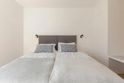 a bedroom with a large white bed with blue pillows at Apartment Bela Bovec in Bovec