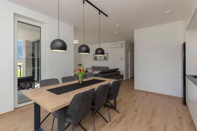 a dining room and living room with a table and chairs at Apartment Bela Bovec in Bovec