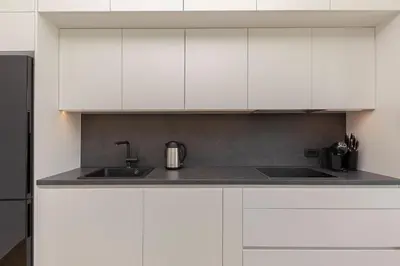 a kitchen with white cabinets and a sink at Apartment Bela Bovec in Bovec