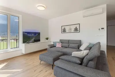a living room with a couch and a tv at Apartment Bela Bovec in Bovec