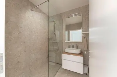 a bathroom with a sink and a shower with a mirror at Apartment Bela Bovec in Bovec