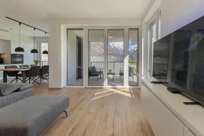 a living room with a television and a dining room at Apartment Bela Bovec in Bovec