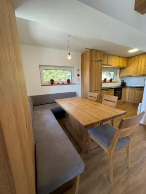 a kitchen and dining room with a wooden table and chairs at Špan Cottage in Jesenice