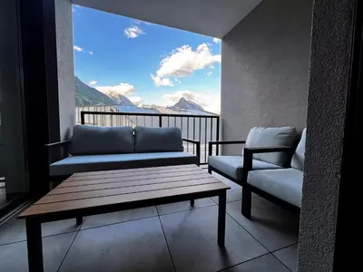 a living room with a couch and a chair on a balcony at Alpine Haven in Bovec