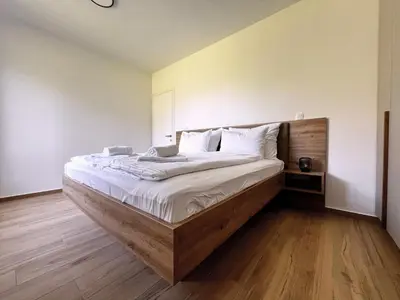 a bedroom with a large bed with a wooden headboard at Alpine Haven in Bovec