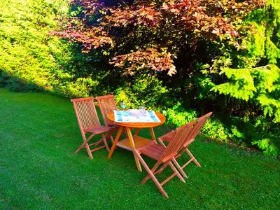 two chairs and a table in the grass at Apartments Ana Kranjska Gora in Kranjska Gora