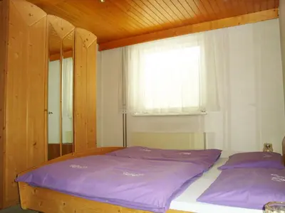 a bedroom with a bed with purple sheets and a window at Apartments Ana Kranjska Gora in Kranjska Gora