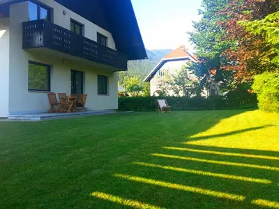 a house with a yard with green grass at Apartments Ana Kranjska Gora in Kranjska Gora