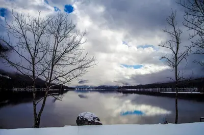a view of a lake with snow on the ground at Holiday House Damjana (Hiška Damjana), Ukanc, Bohinjsko jezero in Bohinj