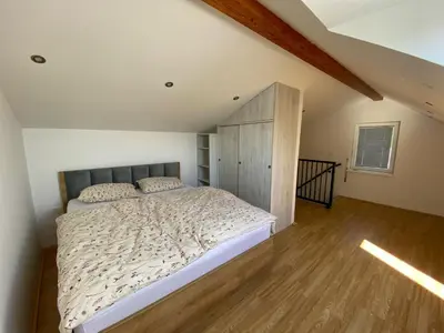 a bedroom with a bed and a wooden floor at Apartmaji Paletino in Turjak