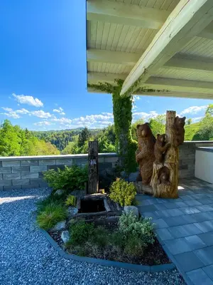 a patio with a tree stump fountain in a garden at Apartmaji Paletino in Turjak