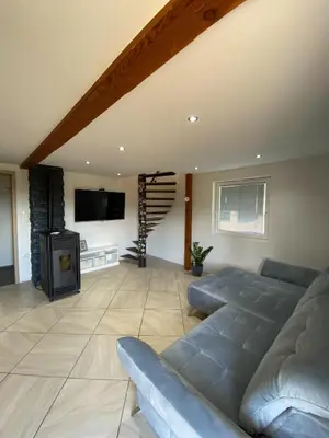 a living room with a couch and a tv and a staircase at Apartmaji Paletino in Turjak