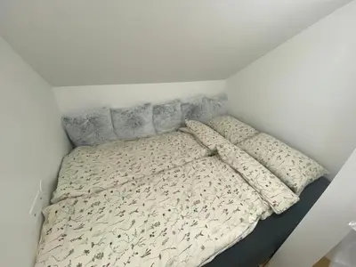 a bed with two pillows on it in a room at Apartmaji Paletino in Turjak