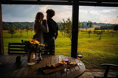 a man and woman standing next to a table with a view at Apartments - Turistična kmetija Vrbnjak in Ljutomer