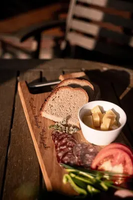 a cutting board with a sandwich and a bowl of cheese at Apartments - Turistična kmetija Vrbnjak in Ljutomer