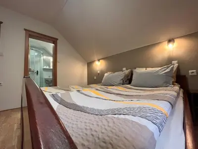 a large bed with two pillows on it in a room at Na Logu - Farm Stay Ambrož Gregorc in Solčava