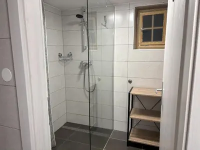 a bathroom with a shower with a glass door at Na Logu - Farm Stay Ambrož Gregorc in Solčava