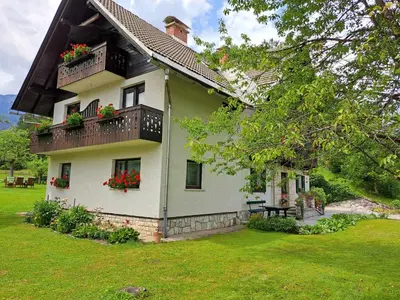 a white house with flower boxes and a balcony at House Škantar Bohinj in Bohinj