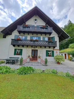 a house with a balcony and a picnic table in front of it at House Škantar Bohinj in Bohinj